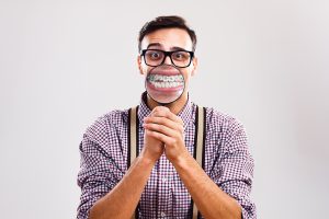 Man magnifying teeth and braces